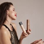 Model spraying the lightweight foundation on her leg to cover imperfections.