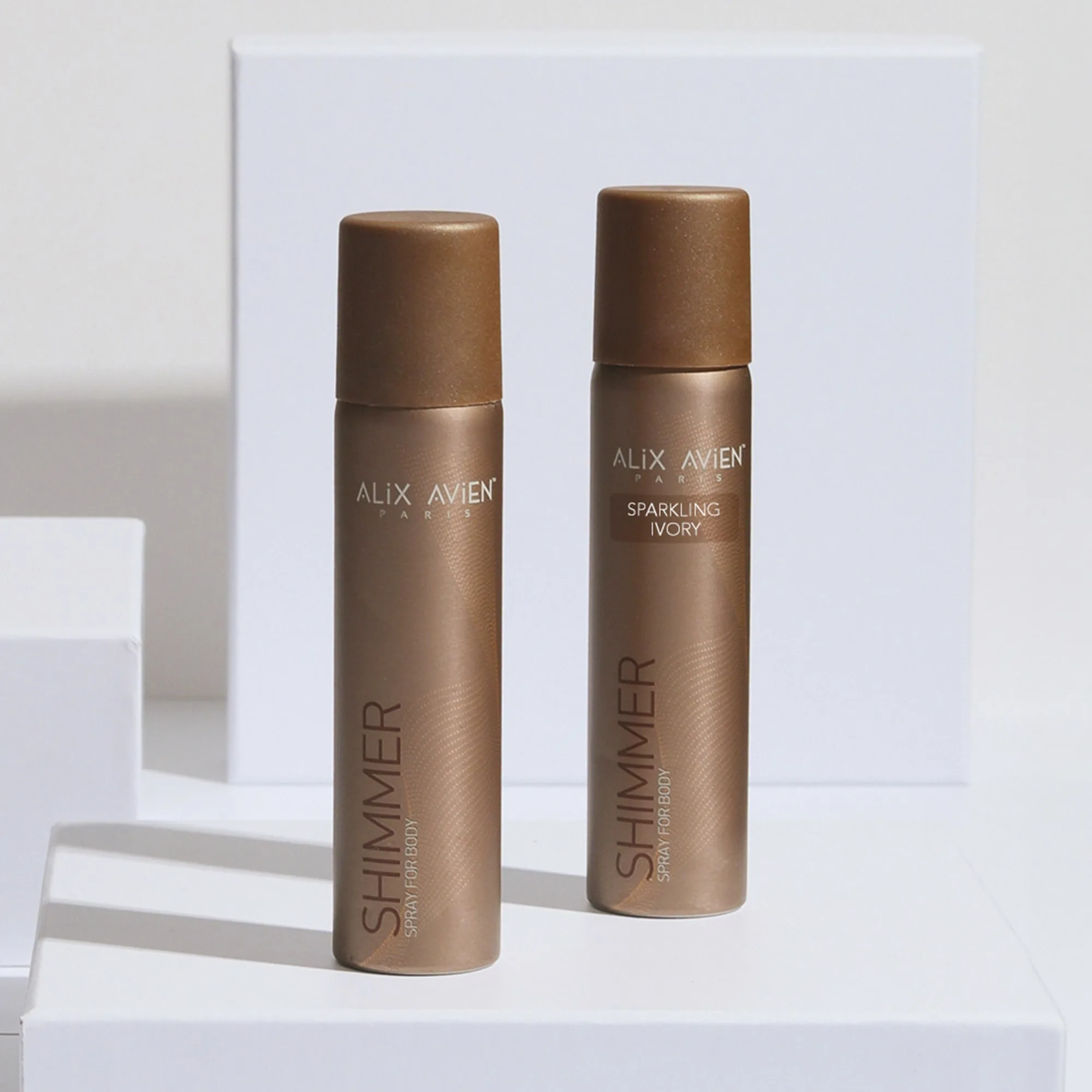 A fine mist of the pearlescent body spray being sprayed to show its lightweight texture.